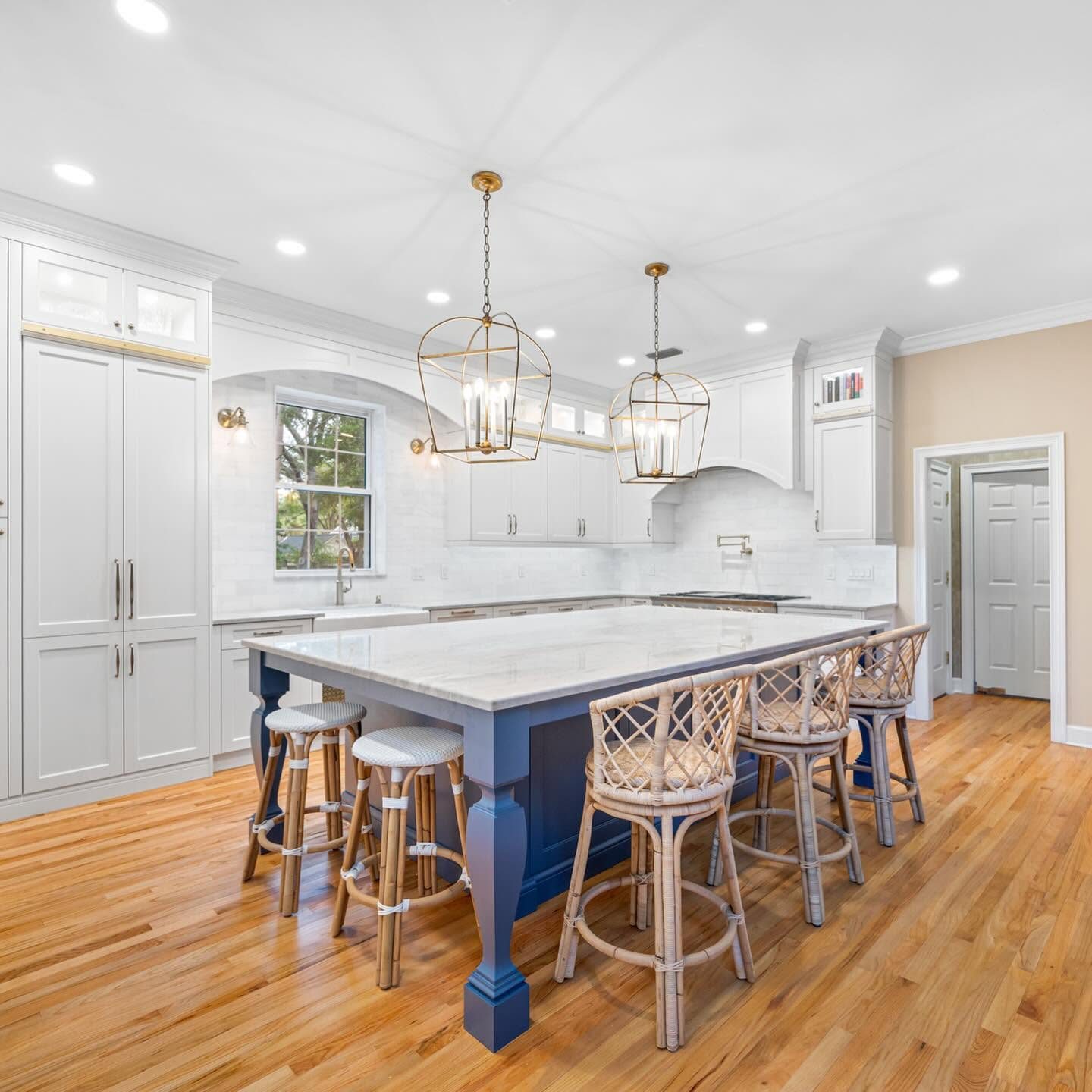 Custom kitchen with navy island and gold pendants